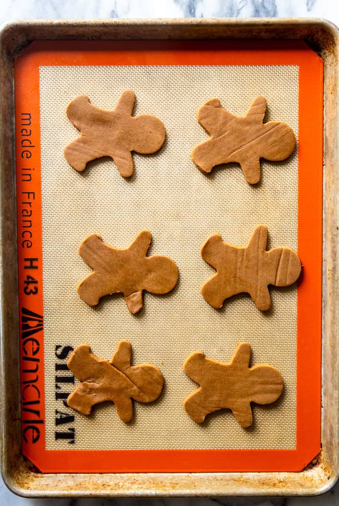 Gingerbread man cookies on a baking sheet before being baked.