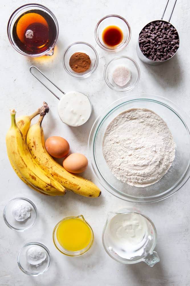 Ingredients for sourdough banana muffins - maple syrup, cinnamon, vanilla extracts, sea salt, mini chocolate chips, bananas, eggs, white wheat flour, sourdough discard, Greek yogurt, butter, baking powder, baking soda