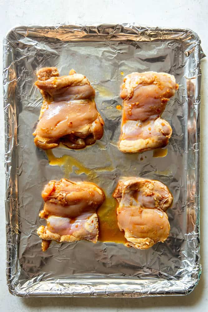 Soy Ginger Chicken Thighs before baking on a sheet pan lined with foil.