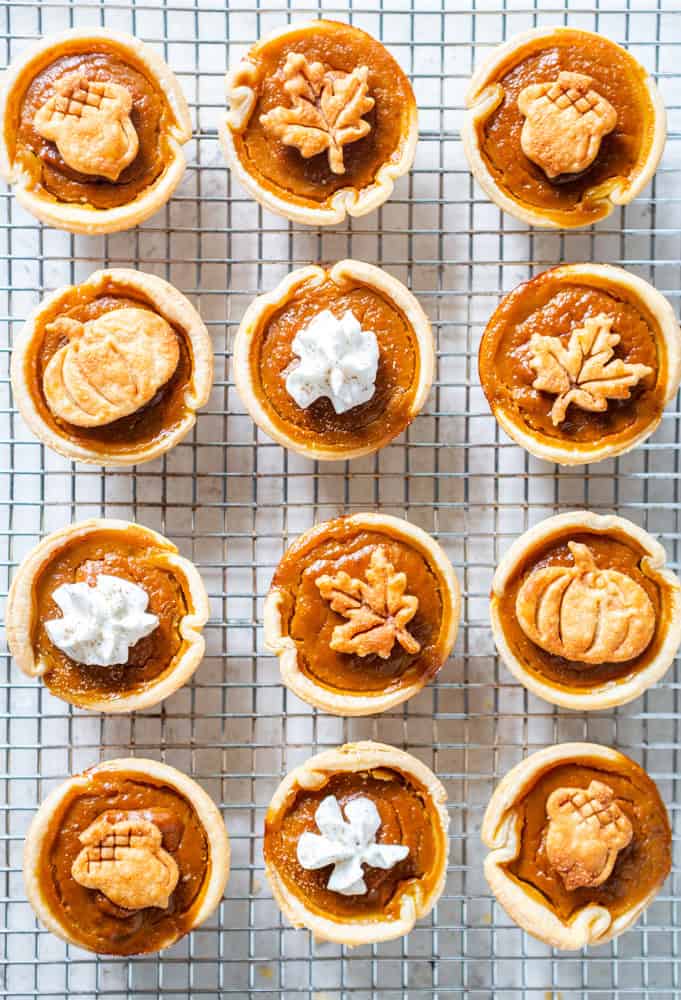 12 mini pumpkin pies on a cooling rack.