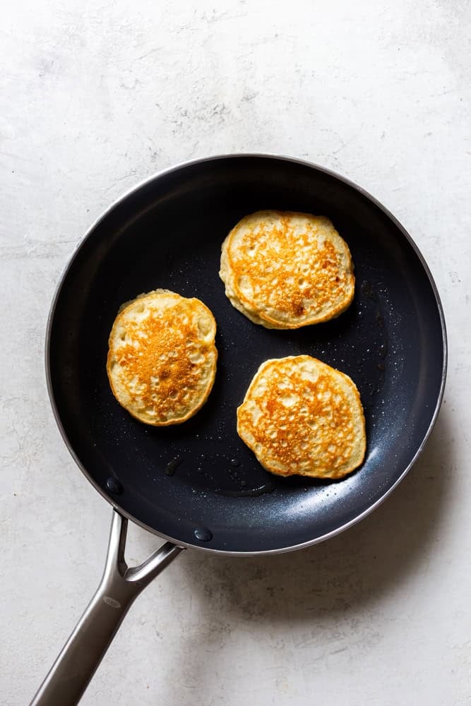 Pancakes cooking on a nonstick pan.