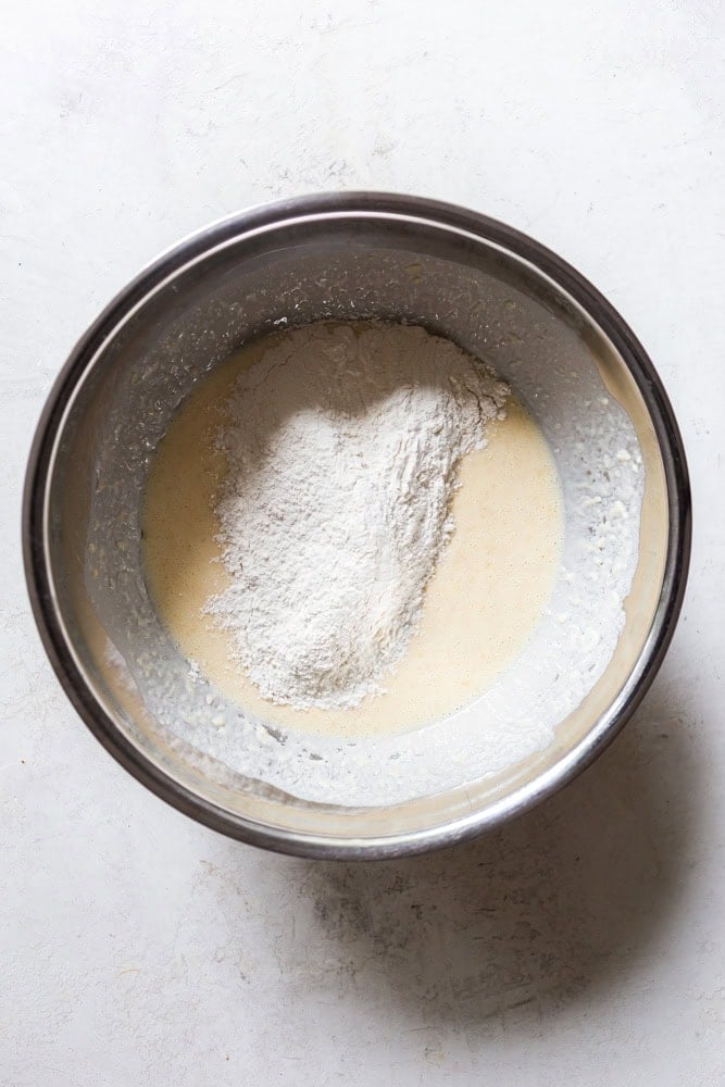 Adding dry ingredients to wet ingredients.