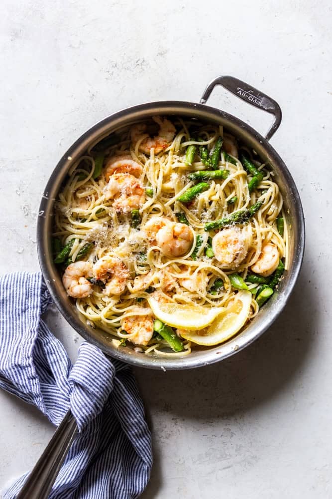 Pan of pasta with shrimp and asparagus.